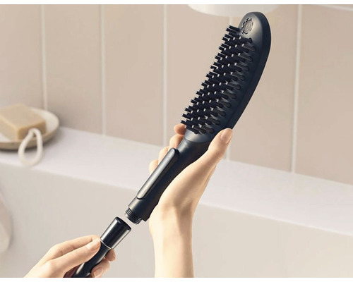 Sprchová hlavica s kefou a hadicovou prípojkou v ruke