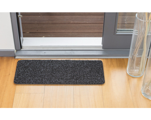 Čistiaca rohožka pred terasovými dverami na drevenej podlahe