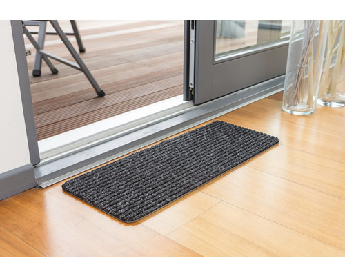 Čistiaca rohožka pred terasovými dverami na drevenej podlahe