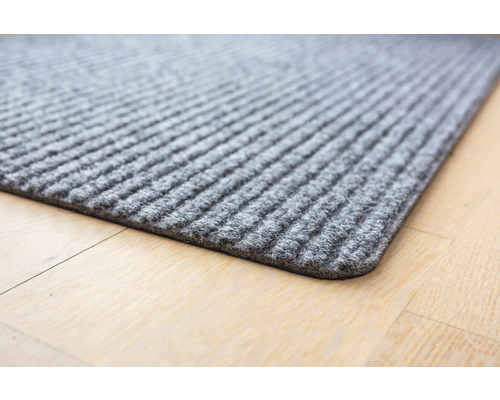 Sivá rohožka s rebrovanou štruktúrou na drevenej podlahe