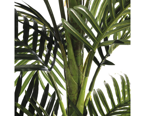 Detailný záber umelej palmy so zelenými listami a kmeňom