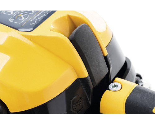 Detailný pohľad na žltú časť krytu motora s vypínačom a značkou stop