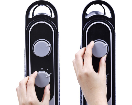 Detailný záber ruky nastavujúcej otočný gombík na radiátore.