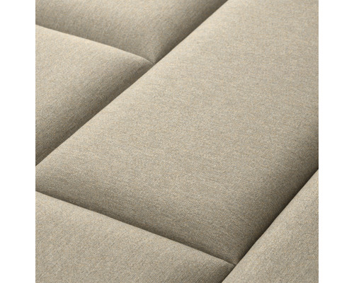 Detail béžovej pohovky s prešívaným povrchom