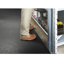 Scéna s osobou stojacou pred regálom na podložke