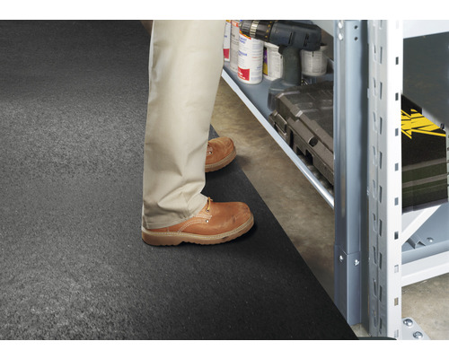 Scéna s osobou stojacou pred regálom na podložke