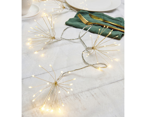 Dekoratívna svetelná reťaz so vzorom hviezd na stole