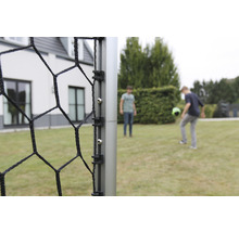 Detailný pohľad na futbalovú bránku so sieťou a dvoma hrajúcimi osobami v pozadí