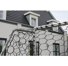 Detailný pohľad na futbalovú bránku so sieťou pred domom