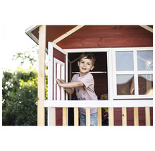 Chlapec v drevenom domčeku na hranie s oknami a dverami