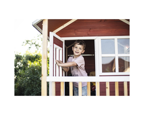 Chlapec v drevenom domčeku na hranie s oknami a dverami