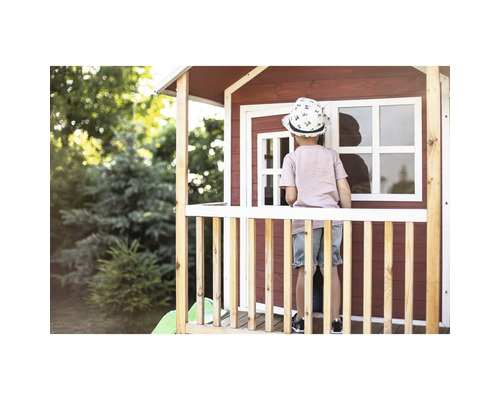Dieťa na verande domčeka na hranie v záhrade.