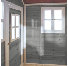 Vnútorný pohľad na hrací domček so šedo natretými drevenými stenami a bielymi okennými rámami