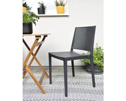 Záhradná scéna so sivou stoličkou, dreveným stolom a rastlinami na vzorovanom koberci