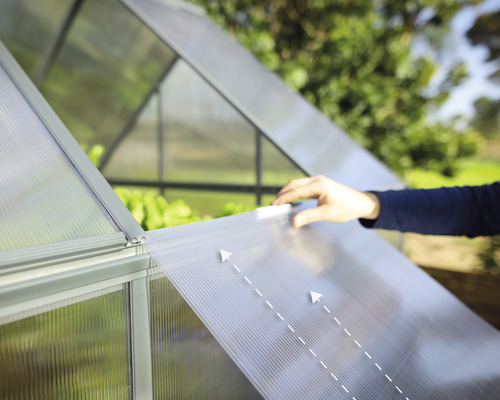 Detailný pohľad na skleník s osobou posúvajúcou priehľadnú dosku