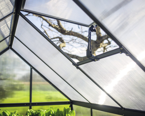 Vnútorný pohľad na skleník s priehľadnými panelmi a vetracím oknom