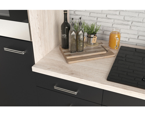 Kuchynský kút s drevenou pracovnou doskou, fľašami, doskami na krájanie a varnou doskou