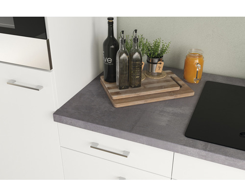 Kuchynská scéna s pracovnou doskou, varnou doskou, doskami na krájanie, fľašami oleja, bylinkami a džúsom