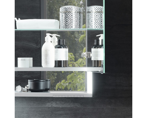 Kúpeľňová zrkadlová skrinka so sklenenými policami a rôznymi kúpeľňovými potrebami