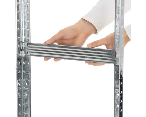 Detailný pohľad na osobu vkladajúcu kovový prvok do regálového systému