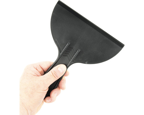 Čierna plastová škrabka držaná v ruke.