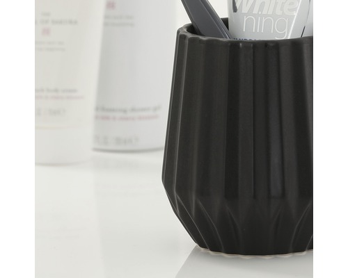 Čierny pohár na zubné kefky so zubnou kefkou a zubnou pastou