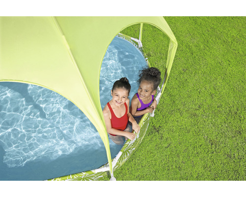 Dve deti sa hrajú v bazéniku so slnečnou ochranou na trávniku.