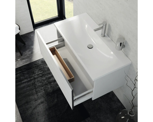 Skrinka pod umývadlo s otvorenou zásuvkou, umývadlo na dosku, vodovodná batéria a kúpeľňové doplnky vo svetlej kúpeľni.