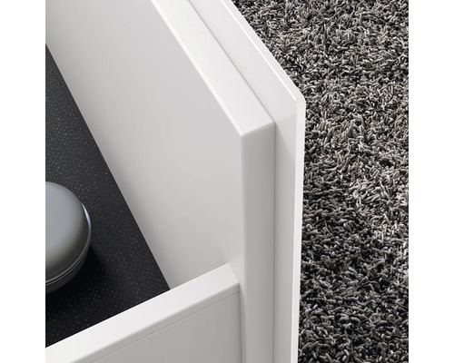 Detailný záber bielej kúpeľňovej skrinky s kobercom