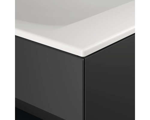 Detailný pohľad na kúpeľňovú skrinku s bielym umývadlom a tmavou prednou stranou