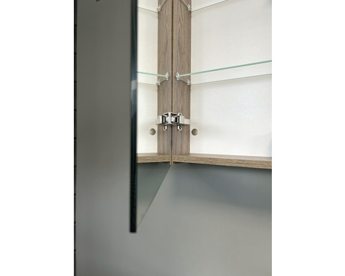 Detailný pohľad na zrkadlovú skrinku s drevenými prvkami a sklenenými policami