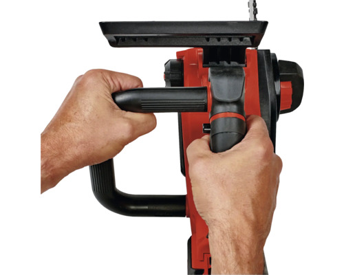 Osoba drží v oboch rukách reťazovú pílu.