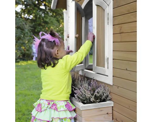 Dieťa otvára okno na drevenom hracom domčeku s kvetináčom.