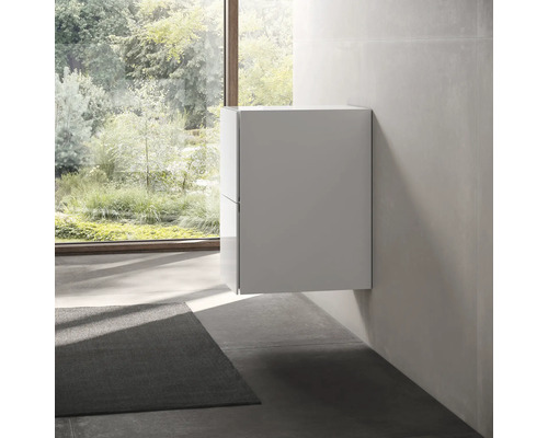 Moderná kúpeľňa s umývadlovou skrinkou namontovanou na stene.