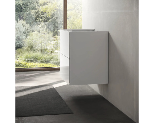 Kúpeľňa s modernou závesnou skrinkou pod umývadlo a výhľadom z okna do zelene