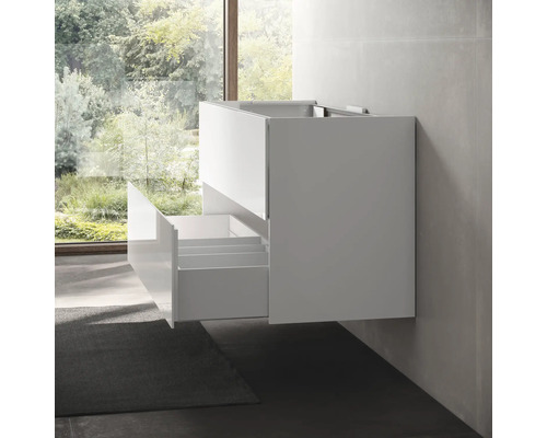 Biela skrinka pod umývadlo s otvorenými zásuvkami namontovaná na stene kúpeľne