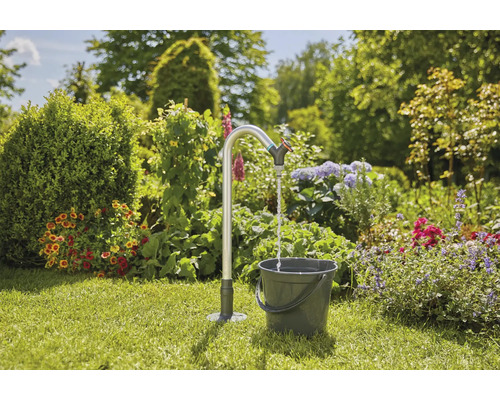 Záhradná scéna s kohútikom a vedrom na trávniku