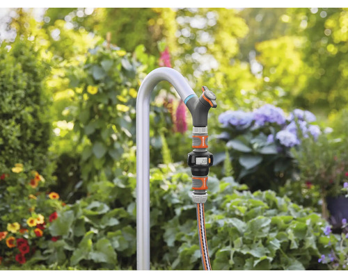 Záhradná scéna s kohútikom, hadicou a digitálnym vodomerom v záhrade