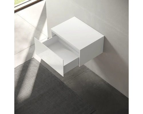 Biela skrinka pod umývadlo s otvorenou zásuvkou namontovaná na stene