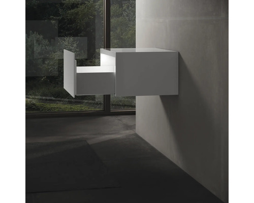 Biela závesná skrinka pod umývadlo s otvorenou zásuvkou v kúpeľni