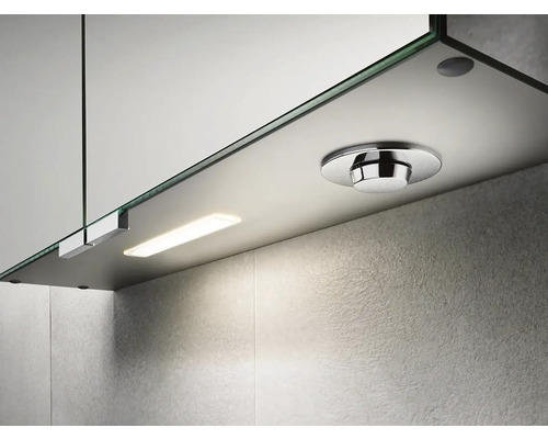 Detailný pohľad na zrkadlovú skrinku s osvetlením a okrúhlym vypínačom