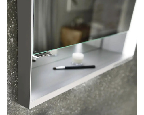 Detail skrinky so zrkadlom s kozmetickým štetcom a krémom