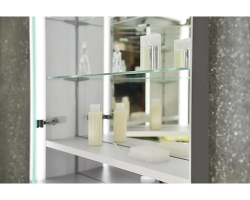 Detailný záber zrkadlovej skrinky so sklenenými policami a kúpeľňovými potrebami