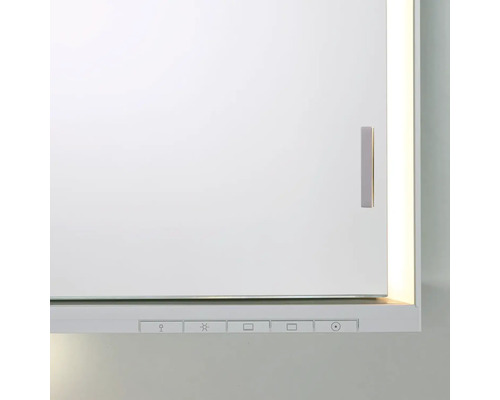 Detail bielej zrkadlovej skrinky s rukoväťou a ovládacími prvkami