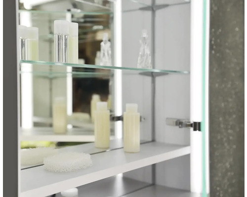 Otvorená zrkadlová skrinka so sklenenými policami a kozmetickými produktmi