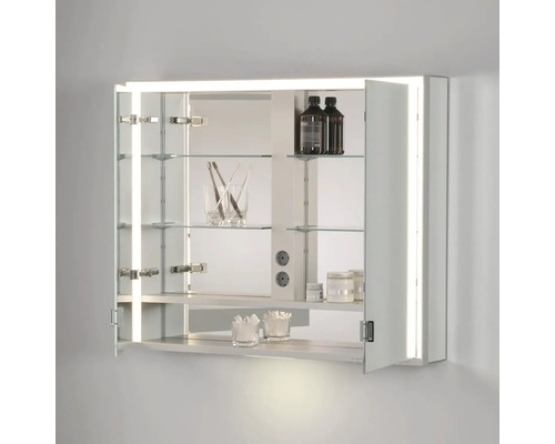 Otvorená zrkadlová skrinka so sklenenými policami, vnútorným osvetlením a kúpeľňovými potrebami