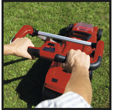 Osoba obsluhuje kosačku na trávu na záhrade.