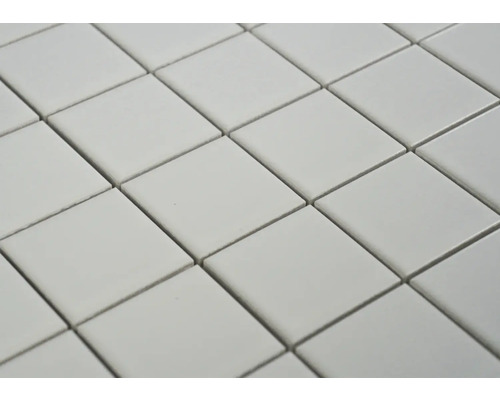 Detailný záber štvorcových dlaždíc usporiadaných diagonálne, vytvárajúcich opakujúci sa vzor.