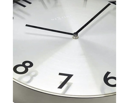 Detail nástenných hodín s hodinovou a minútovou ručičkou a číslicami šesť až osem.