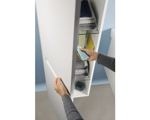 Osoba otvára kúpeľňovú skrinku s policami na uloženie uterákov a kúpeľňových potrieb.